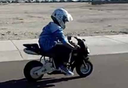 little boy having fun with his ride-on motorbike